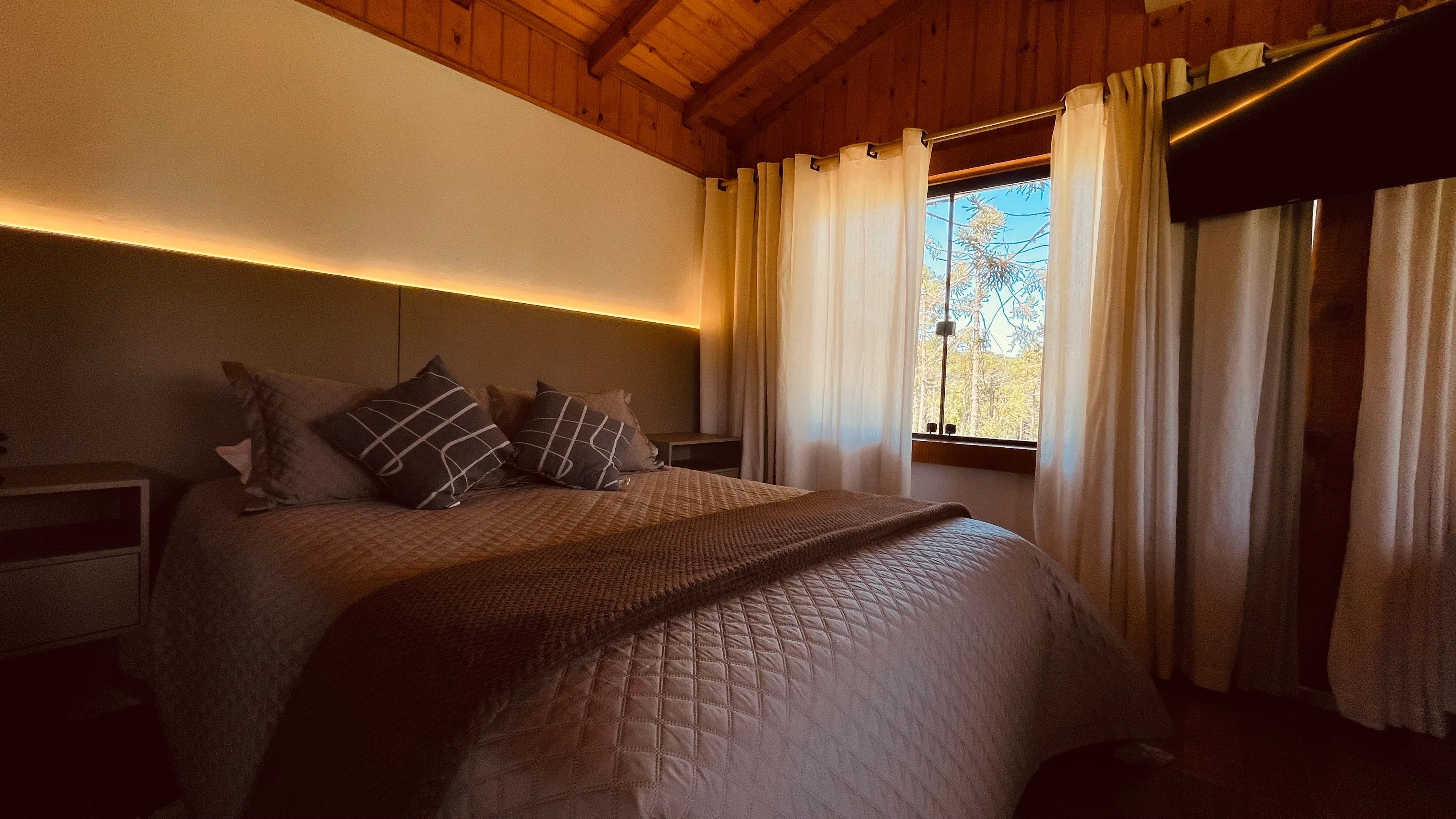 Cama de casal da cabana com iluminação indireta