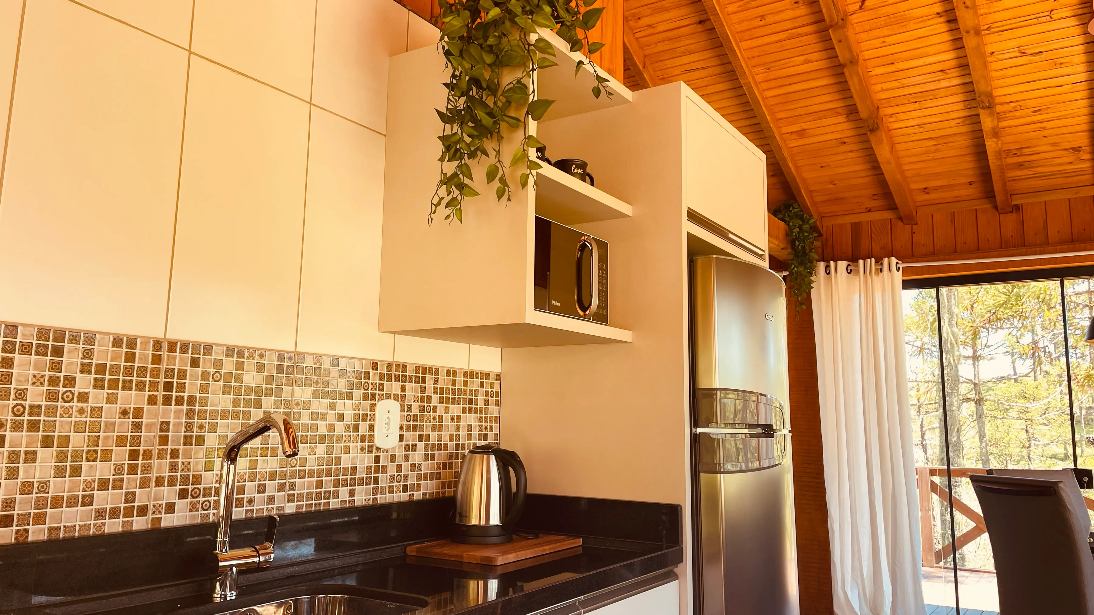 Cozinha da cabana com geladeira e armários claros