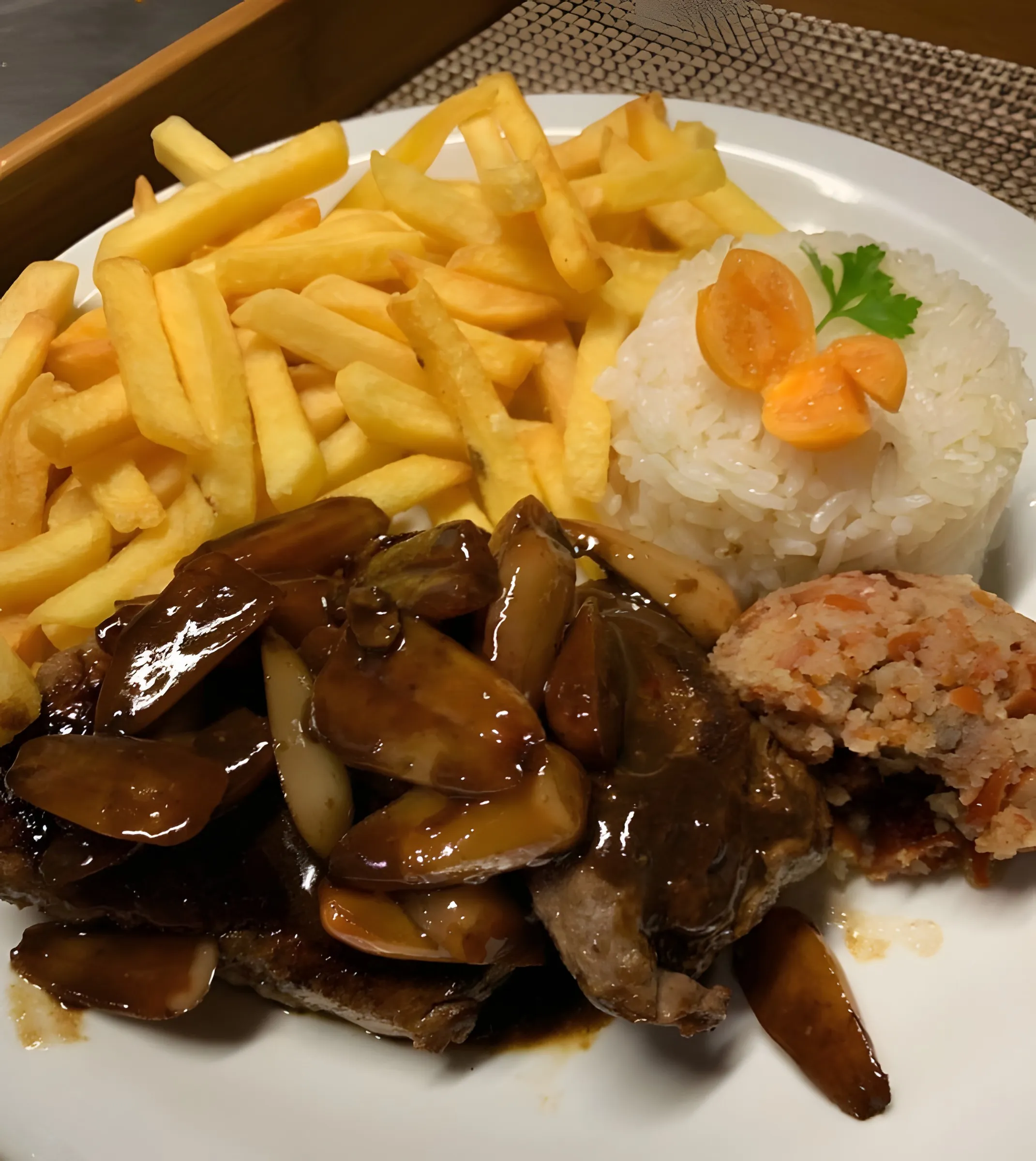 Prato do jantar com carne ao molho, arroz e batatas fritas